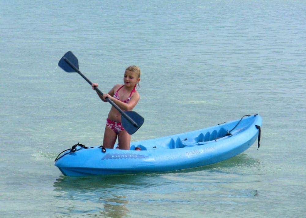 kids learn to kayak in the shallow waters near Motu Moie private island